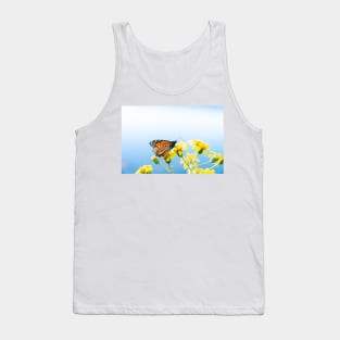 Monarch butterfly resting on yellow daisy against sky background. Tank Top